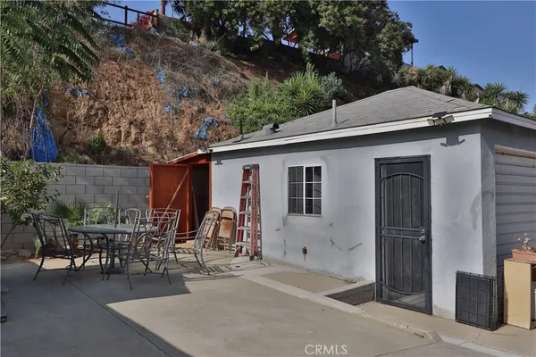 a backyard of a house with table and chairs