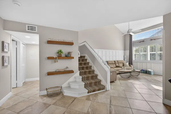 a living room with furniture and a dining table with white walls