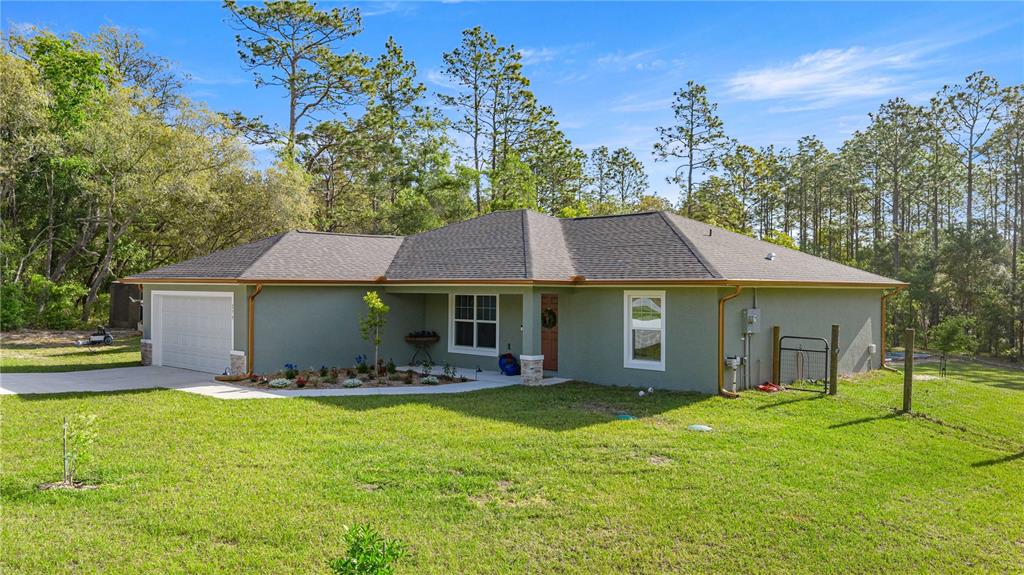 279 Southwest Fig Tree Lane Dunnellon, FL 34431 - Photo 3 of 33 a front view of a house with a garden and yard