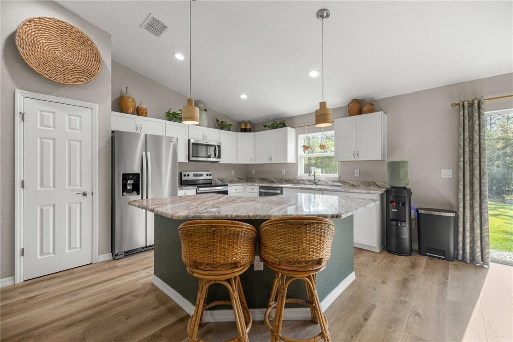279 Southwest Fig Tree Lane Dunnellon, FL 34431 - Photo 10 of 33 a kitchen with kitchen island granite countertop a sink a center island stainless steel appliances and cabinets