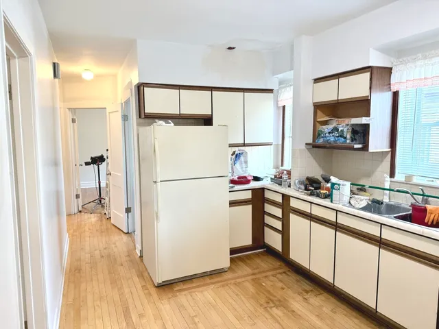a kitchen with a refrigerator a sink and cabinets
