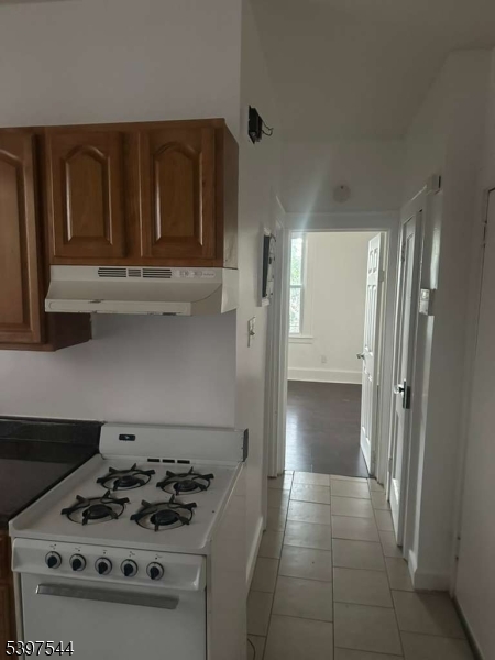231 Alexander Street, Unit 1L Newark, NJ 07106 - Photo 2 of 6 a kitchen with a stove and a refrigerator
