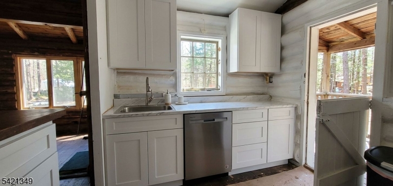 a kitchen with cabinets appliances a sink and a window