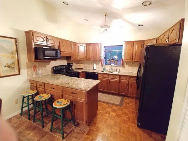 a kitchen with stainless steel appliances a stove a sink a microwave a refrigerator and cabinets