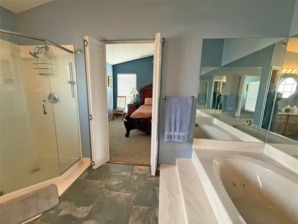 a large en suite bathroom with a tub shower and mirror