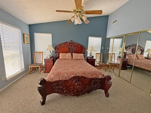 a bed sitting in a spacious bedroom next to a window