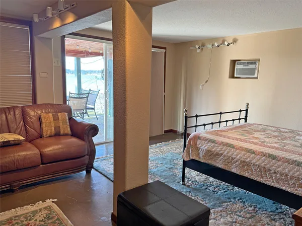 a spacious bedroom with a bed couch and a window