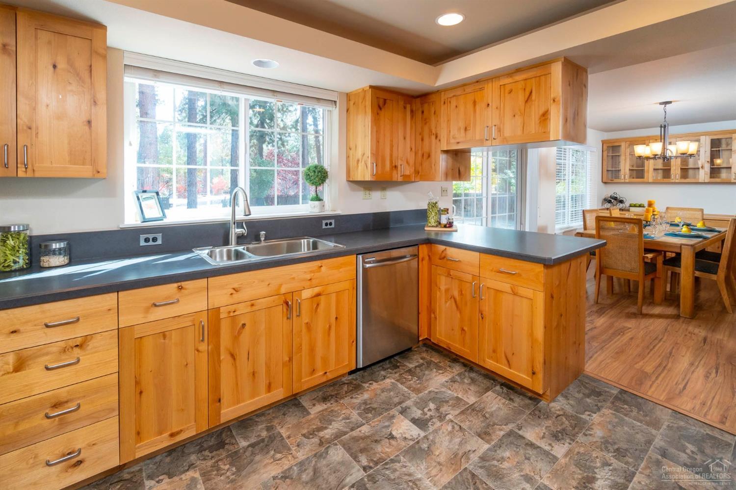 60098 Cinder Butte Road Bend, OR 97702 - Photo 6 of 25 a kitchen with stainless steel appliances granite countertop a sink counter space cabinets and a large window