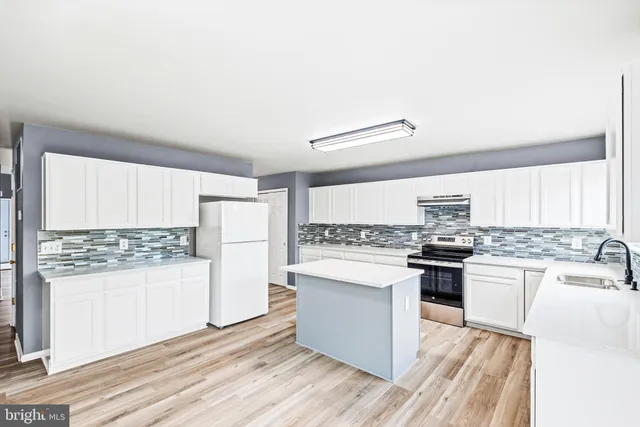 a kitchen with a stove a sink and a refrigerator