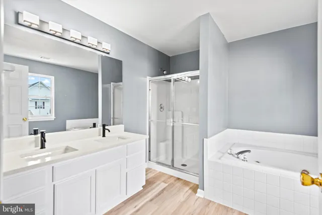 a bathroom with a tub a sink and mirror