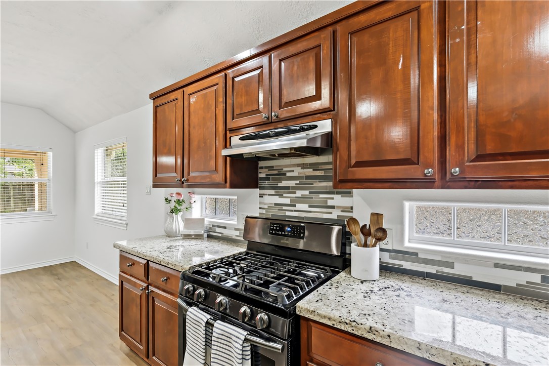 5310 Draycott Court Bryan, TX 77802 - Photo 18 of 31 a kitchen with stainless steel appliances granite countertop a stove a sink and a microwave