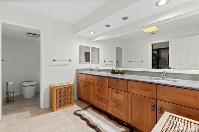 a spacious bathroom with a granite countertop sink mirror and toilet