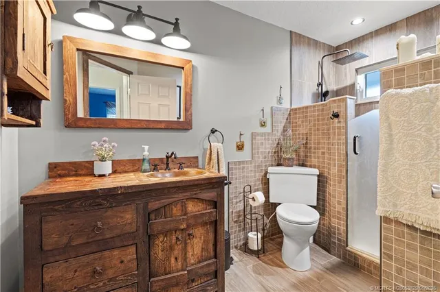 a bathroom with a granite countertop toilet sink and mirror