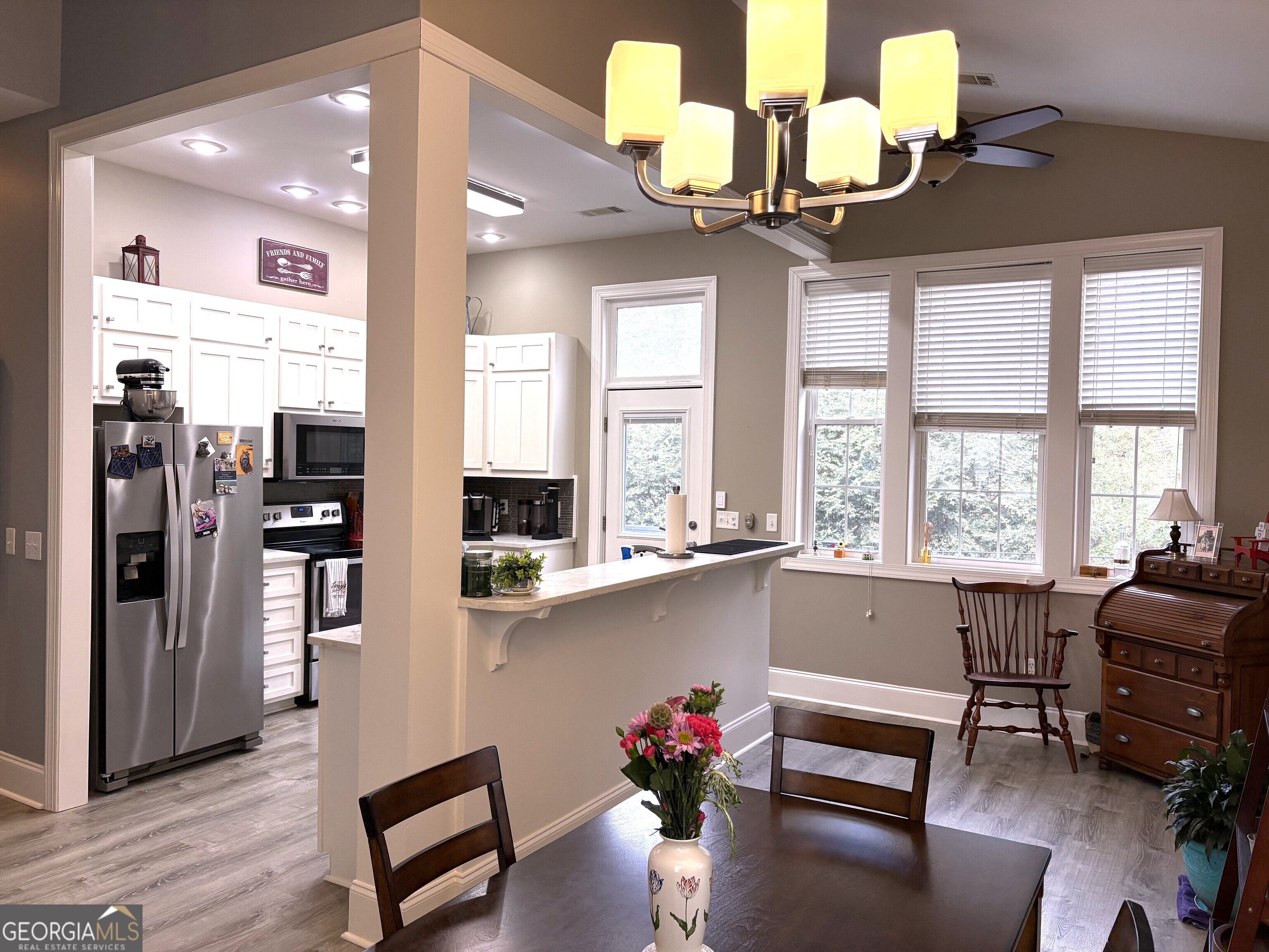 303 Winchester Court Dublin, GA 31021 - Photo 9 of 40 a living room with kitchen island furniture and a chandelier