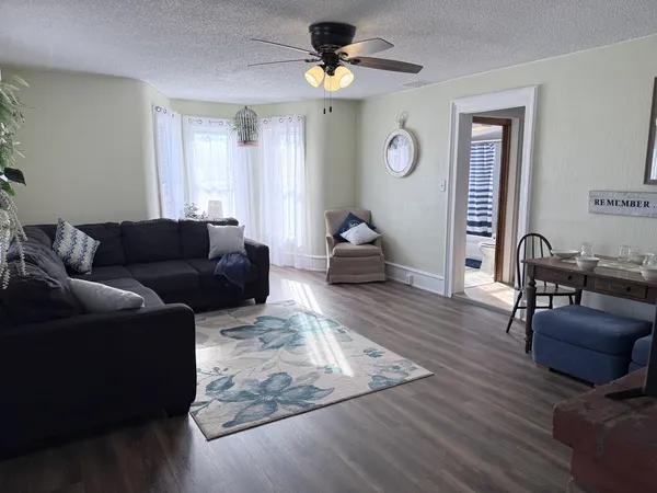 a living room with furniture and a wooden floor