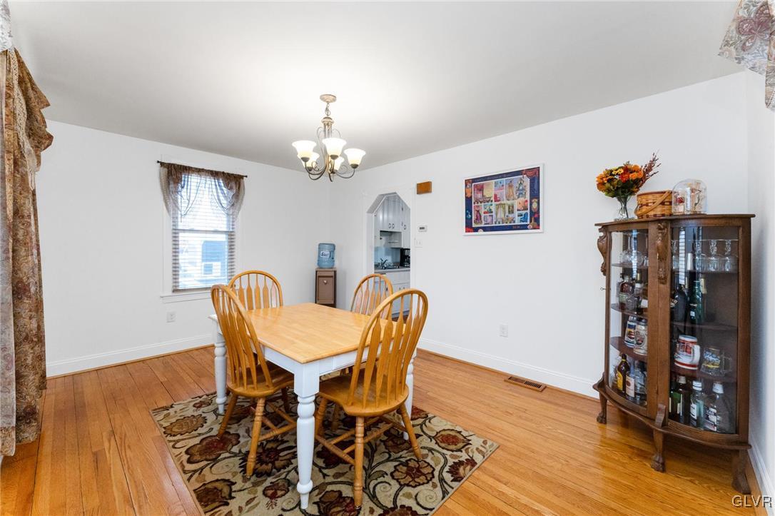 4651 Huckleberry Road Orefield, PA 18069 - Photo 6 of 30 a dining room with furniture wooden floor a rug and a chandelier