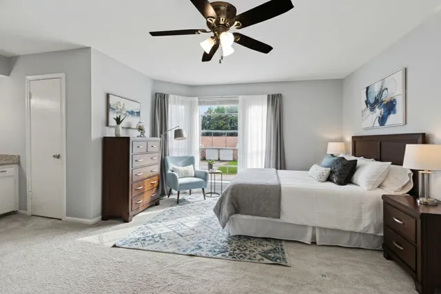 a bedroom with a bed painting on wall and a large window