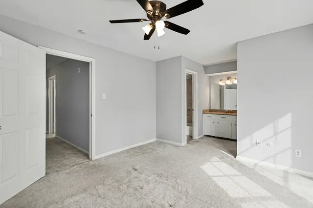 a view of a room with a ceiling fan and entryway