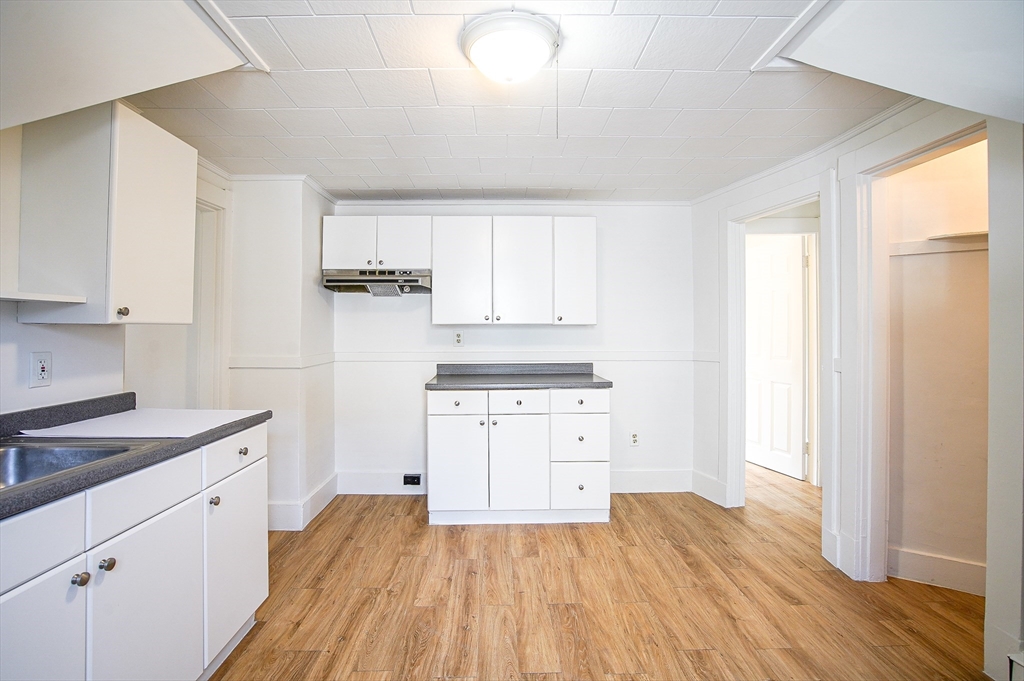 83-85 Wilmont Street, Unit 3 Springfield, MA 01108 - Photo 4 of 12 a kitchen with granite countertop a sink cabinets and wooden floor