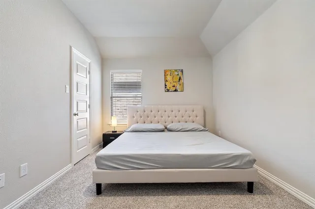 a spacious bedroom with a bed and a window
