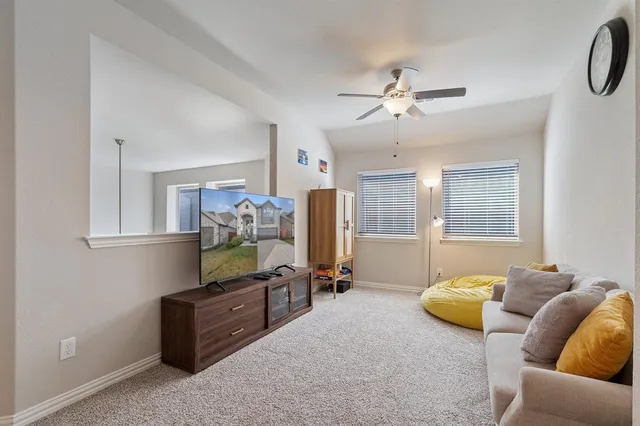 a living room with furniture ceiling fan and a window