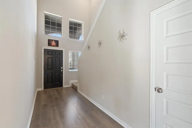 a view of a hallway with wooden floor and entryway