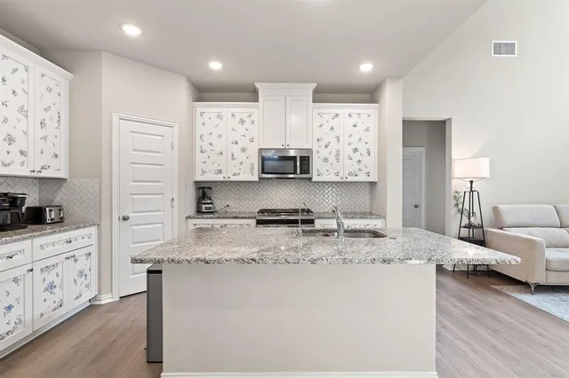 a large kitchen with stainless steel appliances granite countertop a stove a sink and a refrigerator