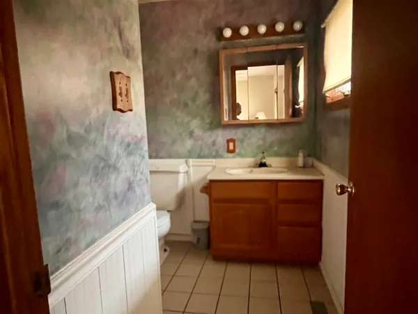 a bathroom with a sink a toilet and mirror