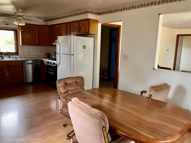 a bedroom with a bed and a refrigerator