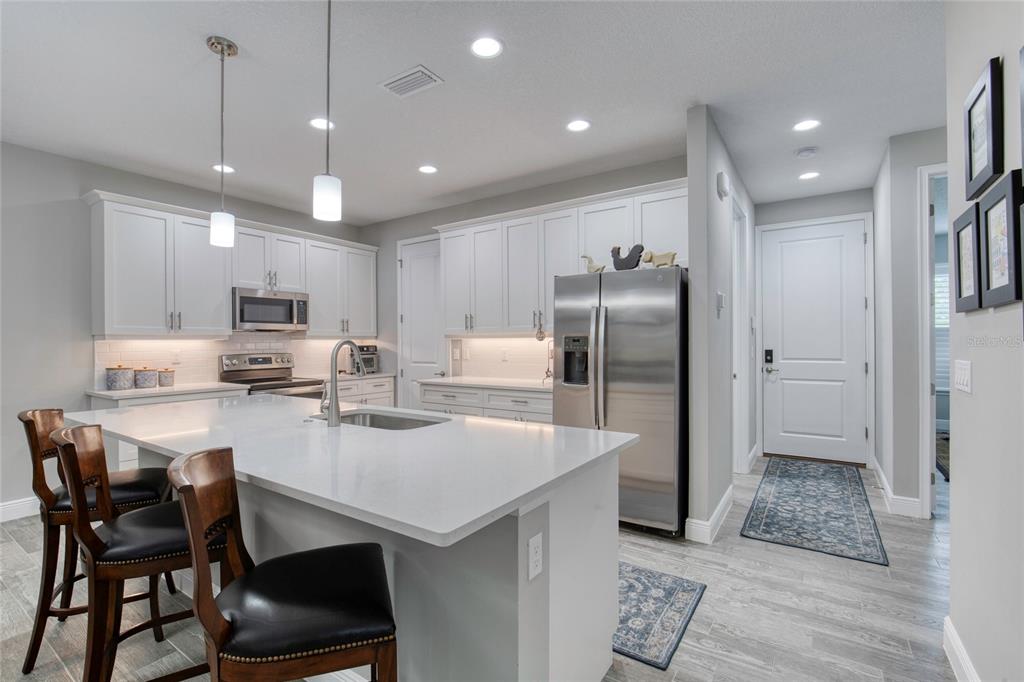 51 Wrendale Loop Ormond Beach, FL 32174 - Photo 15 of 58 a kitchen with stainless steel appliances granite countertop a sink a stove a refrigerator cabinets and chairs