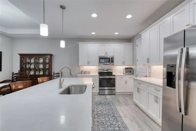 a kitchen with a sink stainless steel appliances and cabinets