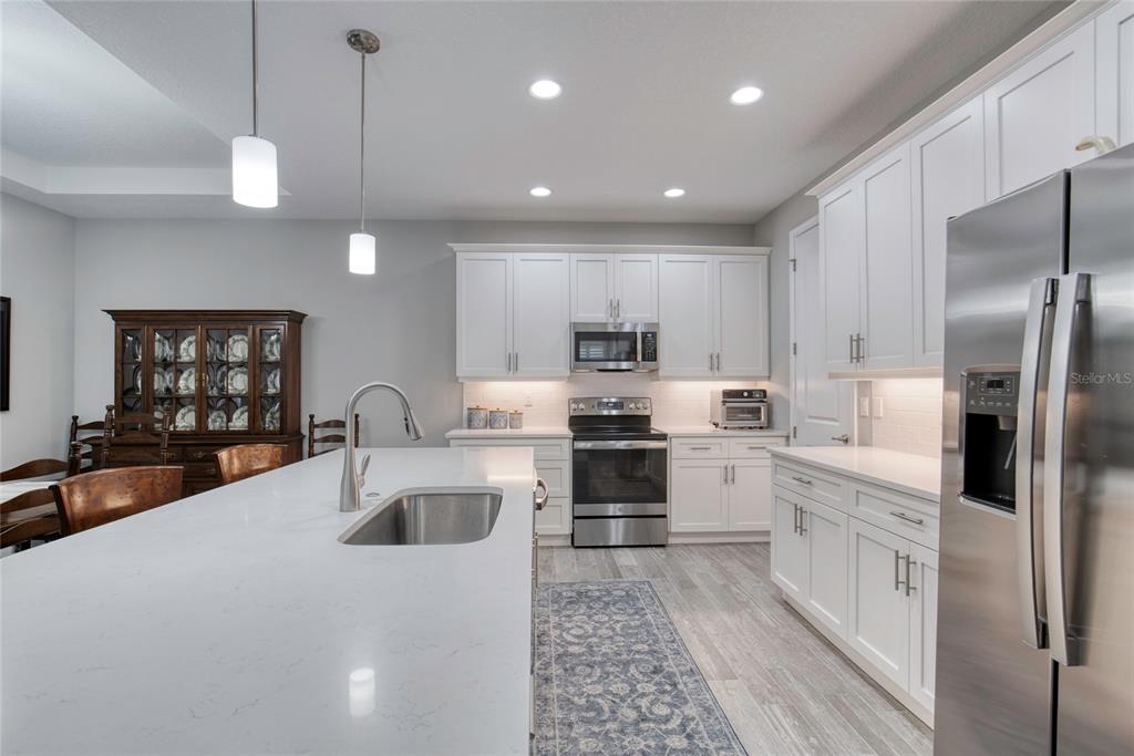 51 Wrendale Loop Ormond Beach, FL 32174 - Photo 16 of 58 a kitchen with white cabinets and stainless steel appliances