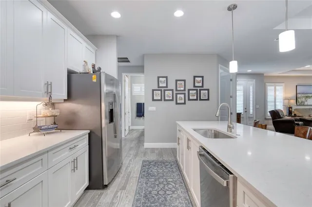a kitchen with kitchen island granite countertop a sink and refrigerator