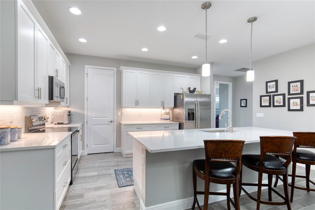 51 Wrendale Loop Ormond Beach, FL 32174 - Photo 20 of 58 a kitchen with kitchen island granite countertop a sink and refrigerator