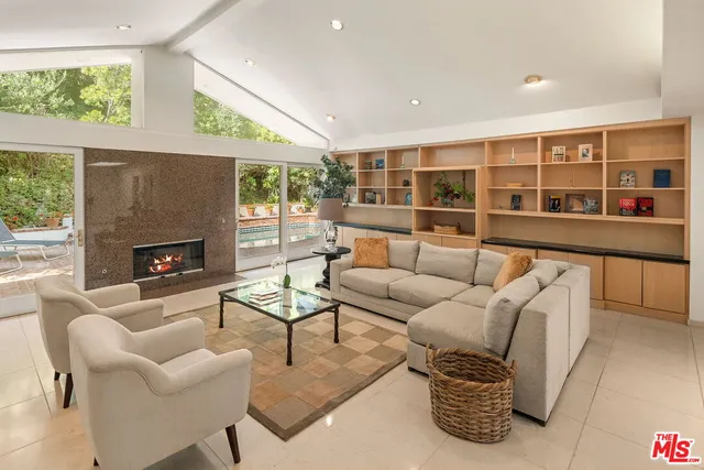 a living room with furniture a fireplace and windows