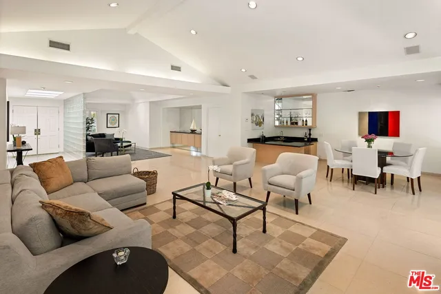 a living room with furniture and a dining table with wooden floor