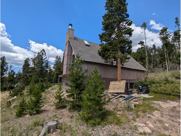 a backyard of a house with table and chairs under an umbrella