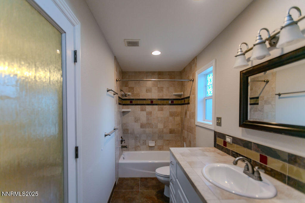43 Ardmore Drive Reno, NV 89509 - Photo 16 of 28 a bathroom with a granite countertop sink a toilet a mirror and shower