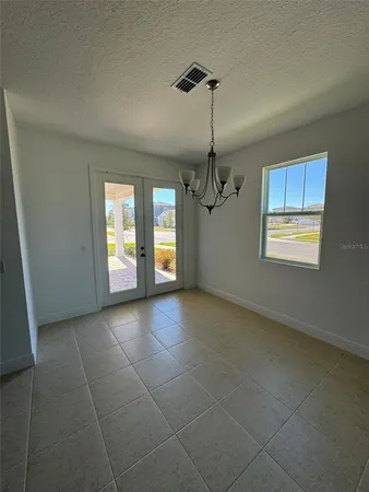a view of a livingroom with a chandelier fan and windows