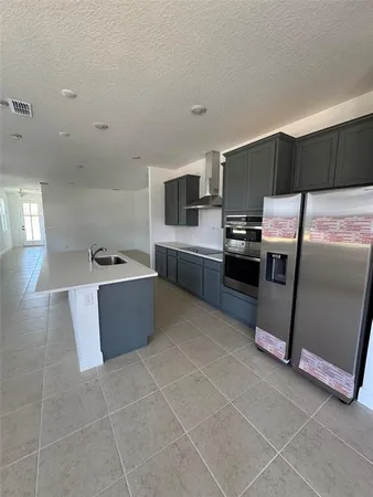 a large kitchen with a stove a sink dishwasher and a refrigerator