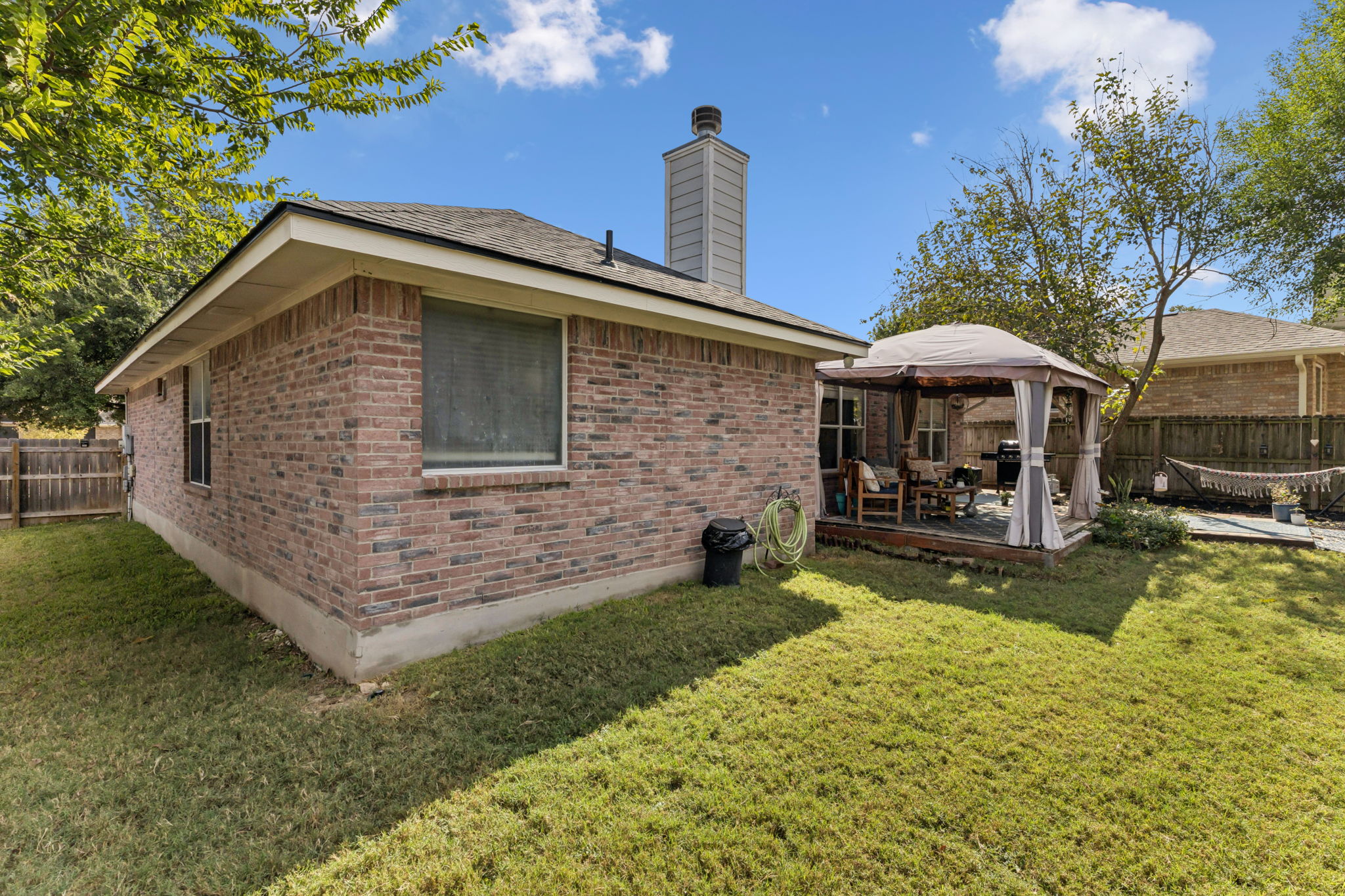 2412 Chestnut Path Round Rock, TX 78664 - Photo 23 of 26 A well-maintained brick exterior highlights this home, featuring a comfortable outdoor gazebo perfect for relaxation.