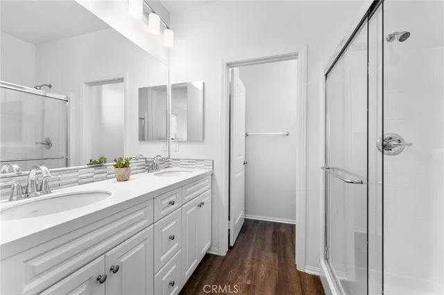 a spacious bathroom with a double vanity sink a mirror and shower