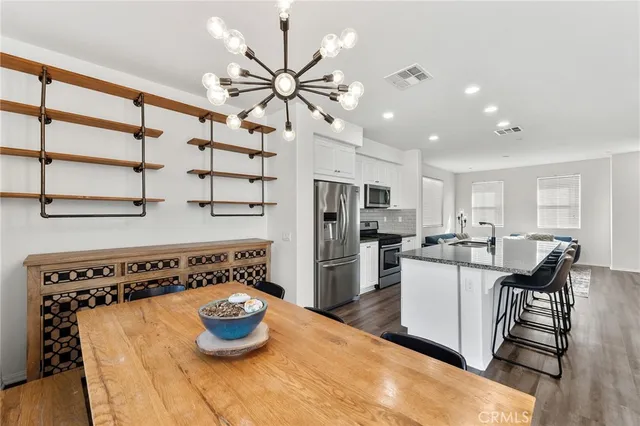 a kitchen with stainless steel appliances a table and chairs