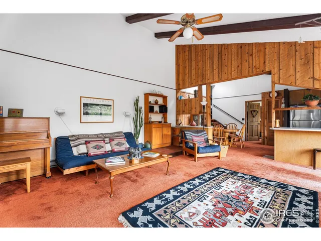 a living room with furniture a rug and white walls