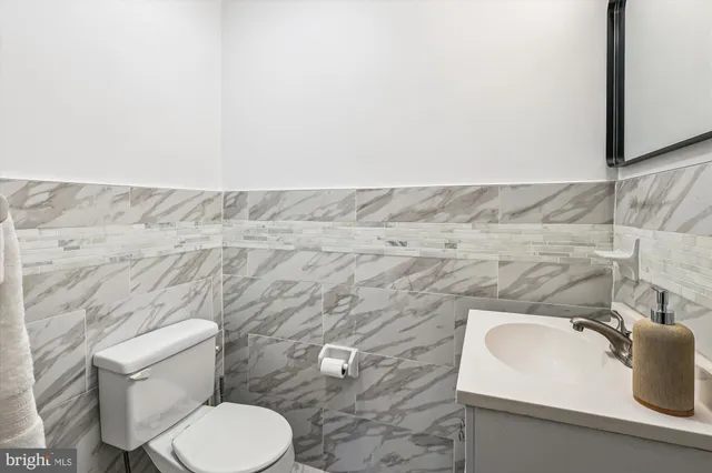 a view of a yard in front of a house with plants and large tree