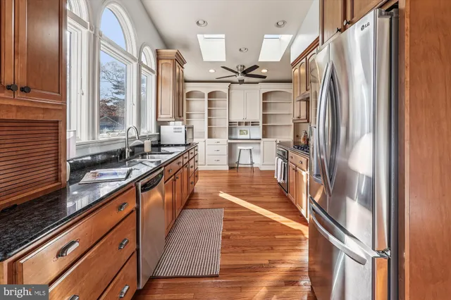 a large kitchen with stainless steel appliances granite countertop a large window and a counter space