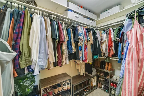a view of walk in closet with clothes