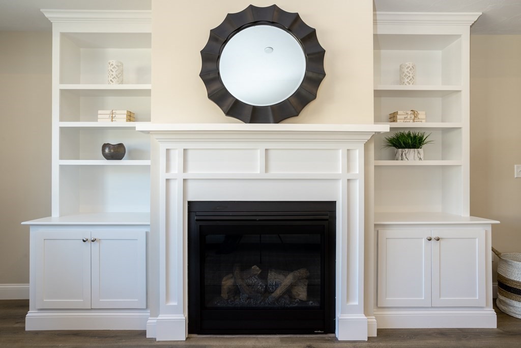 3 Katlyn Circle, Unit 8 Rochester, MA 02770 - Photo 5 of 16 a living room with a fireplace and a clock