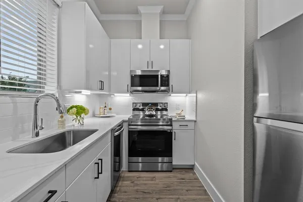 a kitchen with stainless steel appliances granite countertop a sink stove and refrigerator