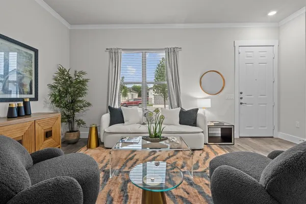 a living room with furniture a large window and a chandelier